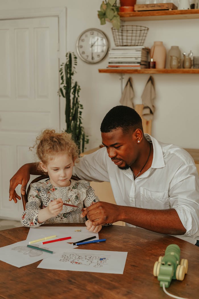 A father and daughter engaged in a creative coloring activity at home, fostering family bonding.